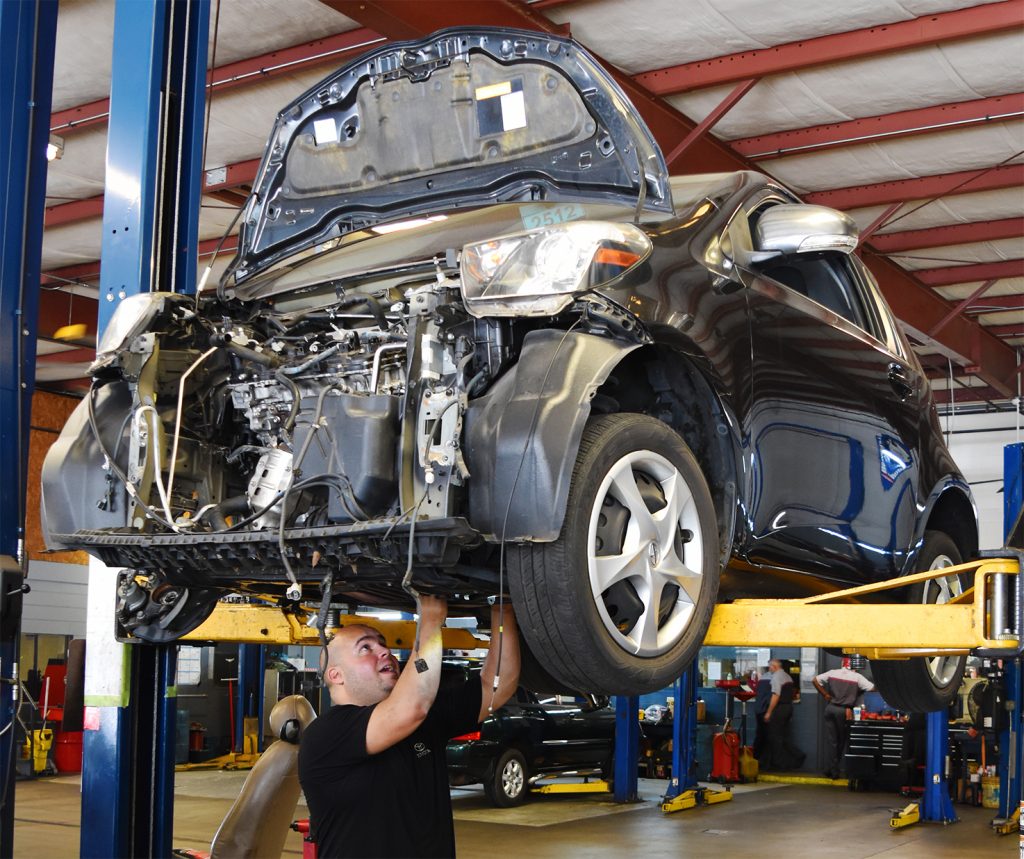 Certified Technician Juan Castillo works to rebuild the engine in a 2012 Scion iQ.